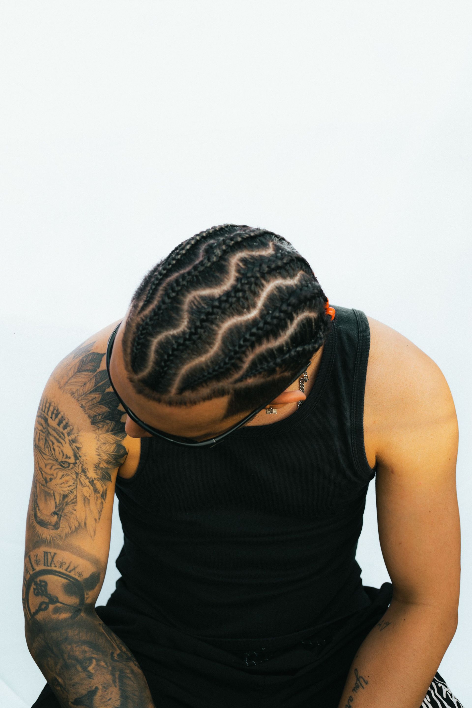 Close-up of a tattooed man with braided hair in São Paulo, Brasil.